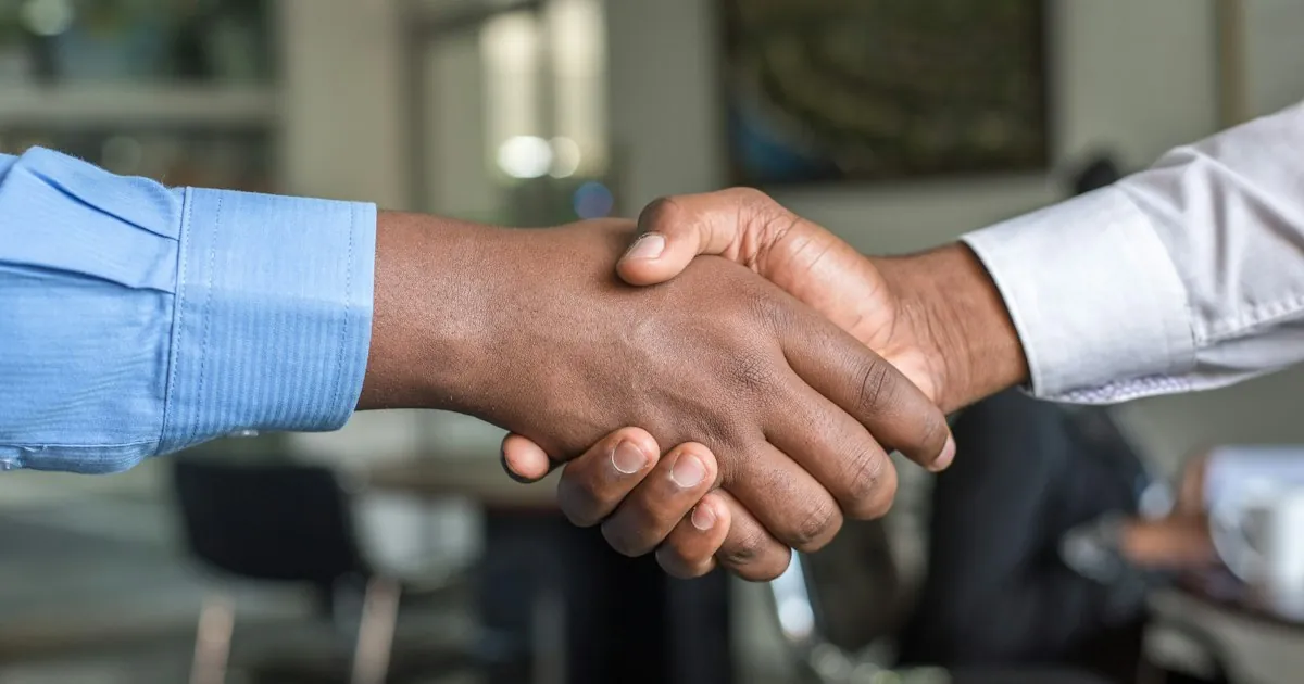 Business professionals collaborating at a meeting table, representing partnership discussions with outsourcing vendors