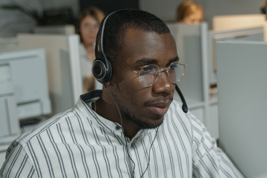 Support team working at computers with headsets in an open office