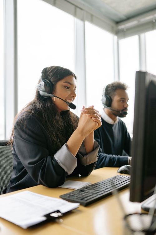 Customer service agent wearing a headset assists a client at a modern call center workstation