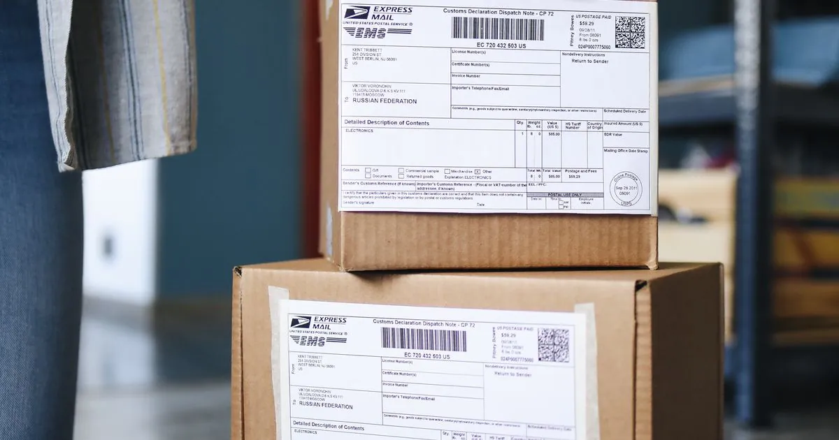 Stacks of brown cardboard boxes with shipping labels ready for delivery in a warehouse