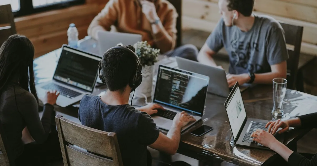 Diverse team collaborating around laptops in a bright office