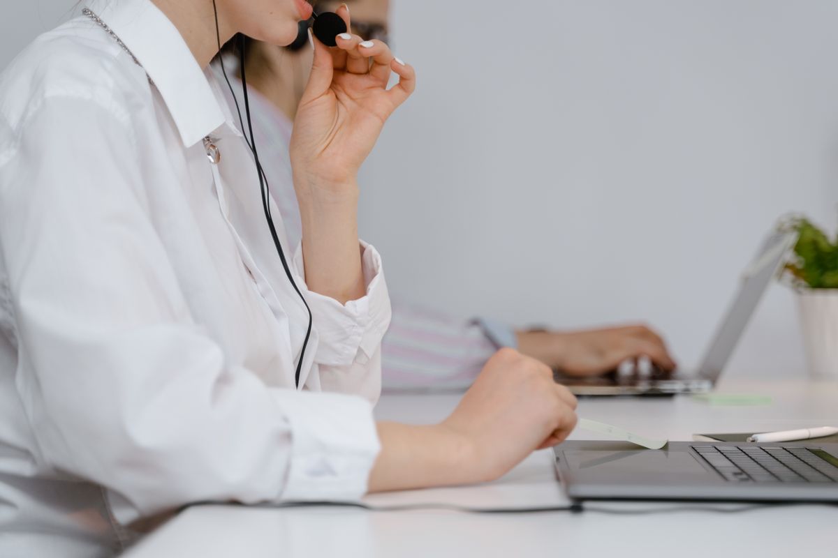 Customer support representative working at a computer with a headset in a modern office
