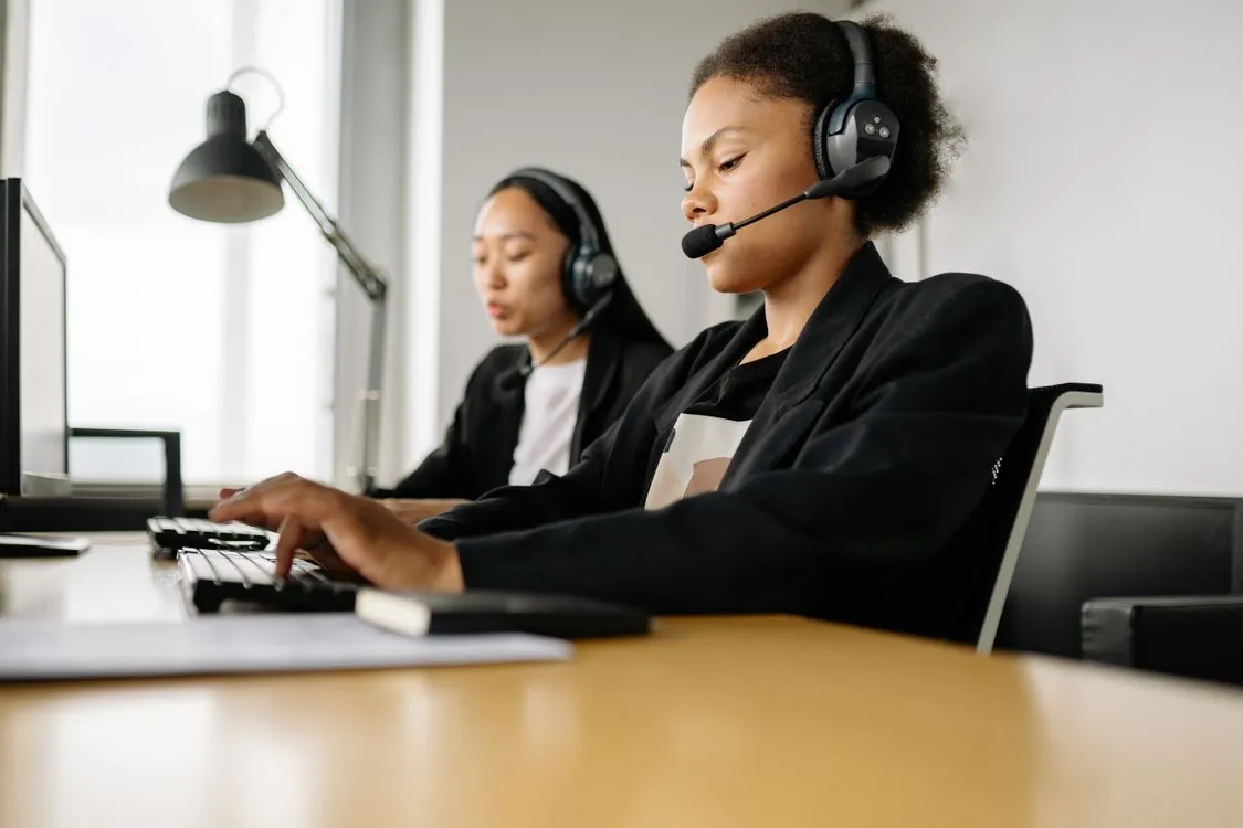 Call center agent wearing a headset and assisting a customer in a modern office
