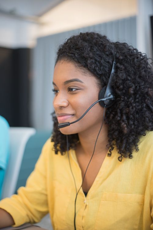 A focused call center agent with a headset provides customer support at a desk